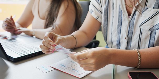 close up of female students reading flash cards during education lesson in classroom.