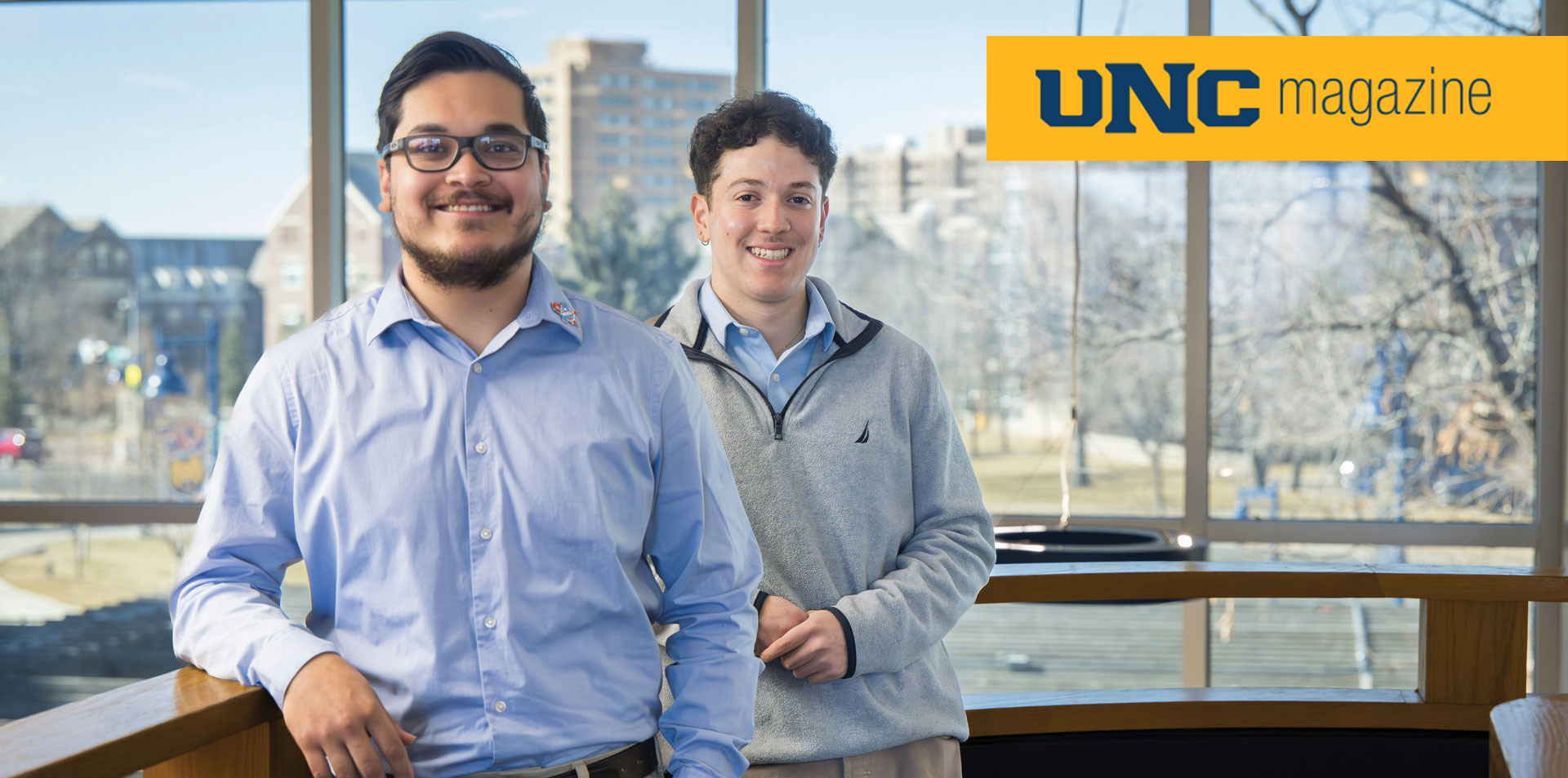 Javier Lomeli and Felix Garcia smiling at the camera, in the back you can see a landscape of Greeley 