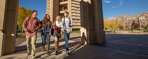Four UNC student walking together on campus.