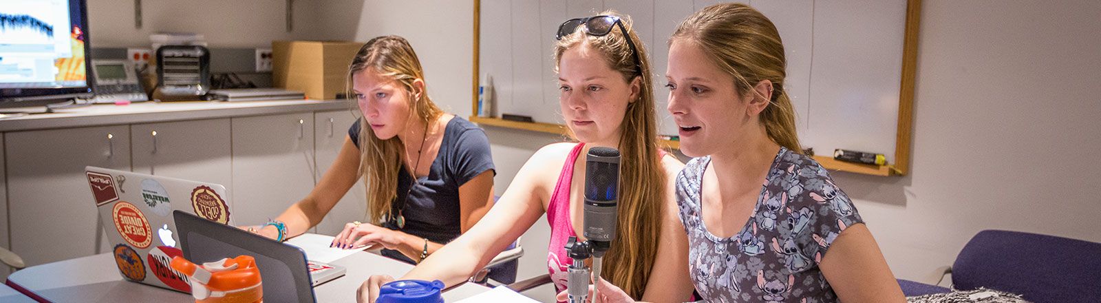 Group of students speaking into microphone in audiology clinic