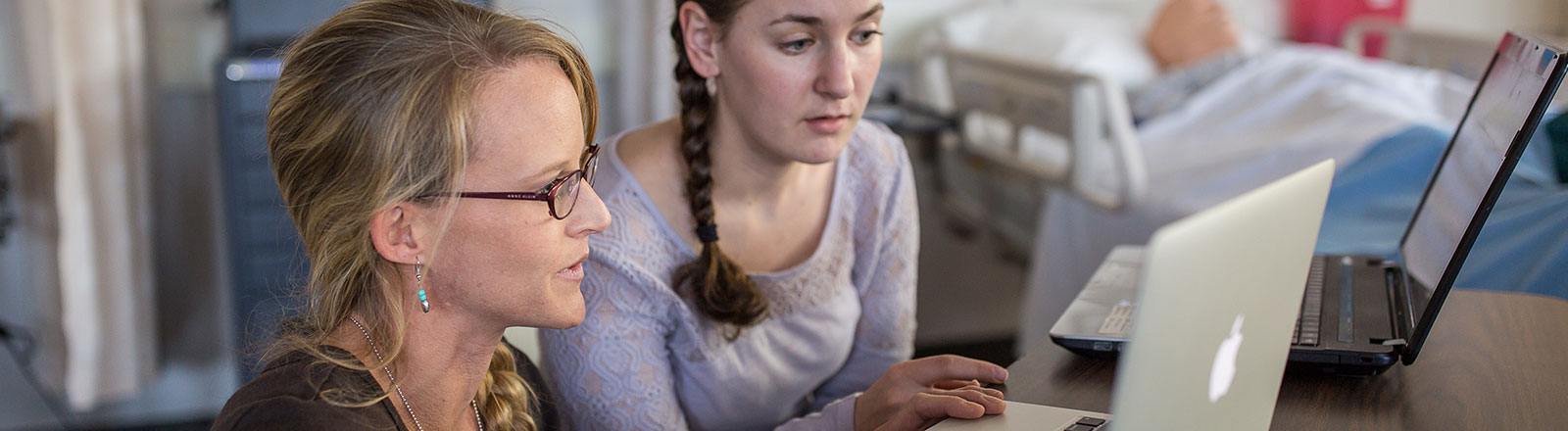 Student and professor observing computer screen