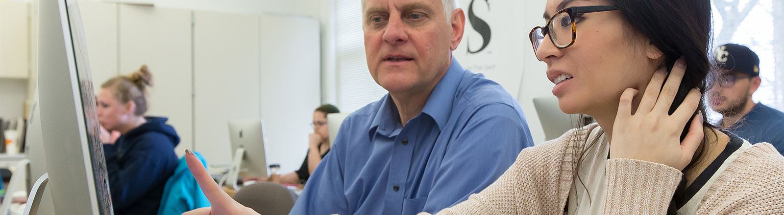 Student and instructor working at desktop computer