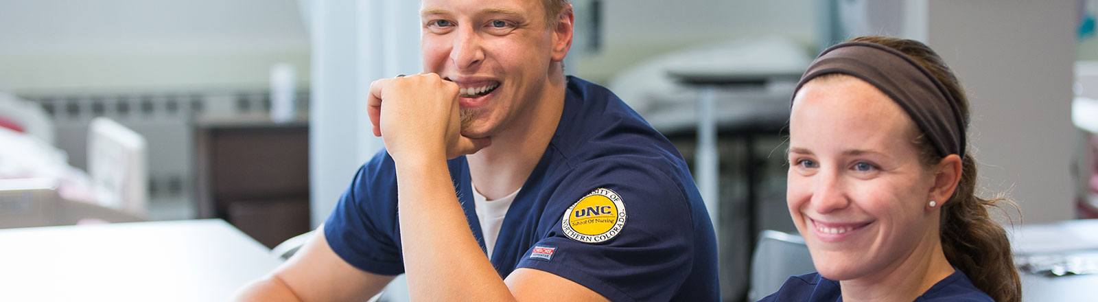 Two students similing in classroom