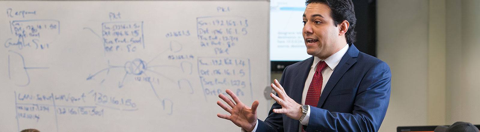 Professor lecturing about Network Address Translation with diagram drawn on white board