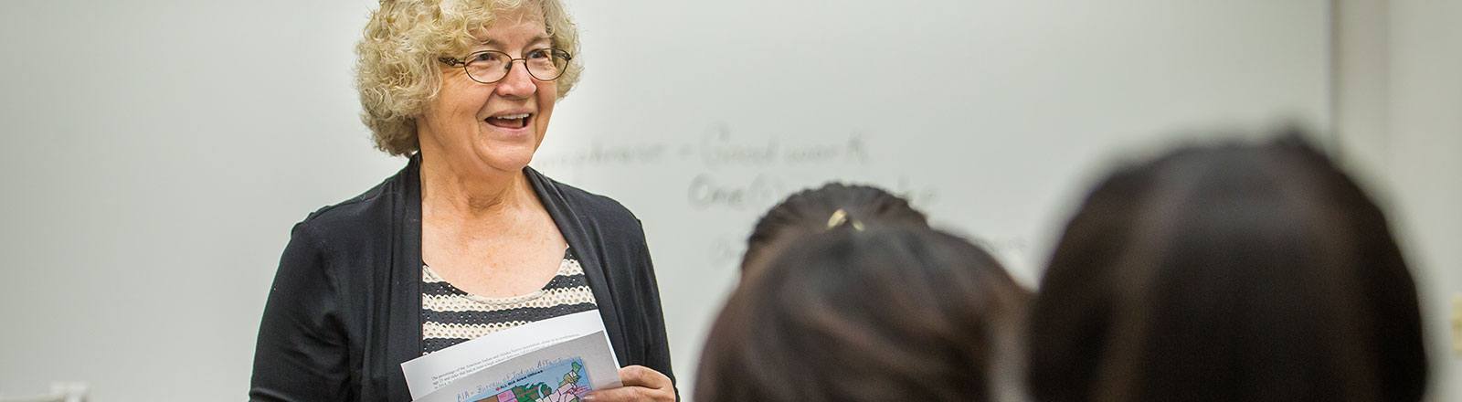 Professor in front of students speaking with paper of United States map
