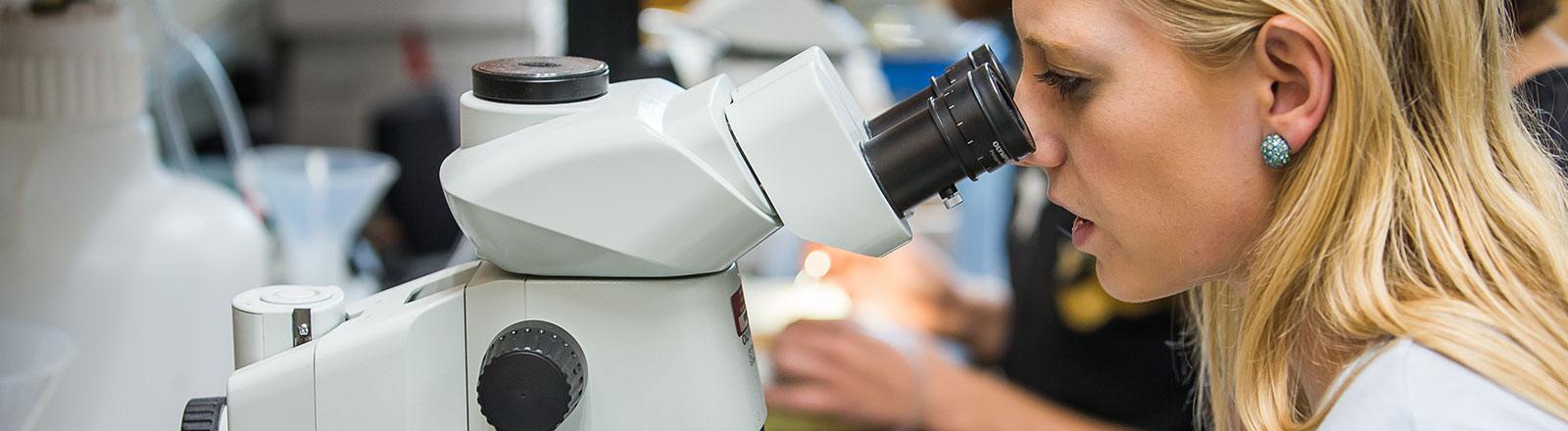 Student looking through microscope