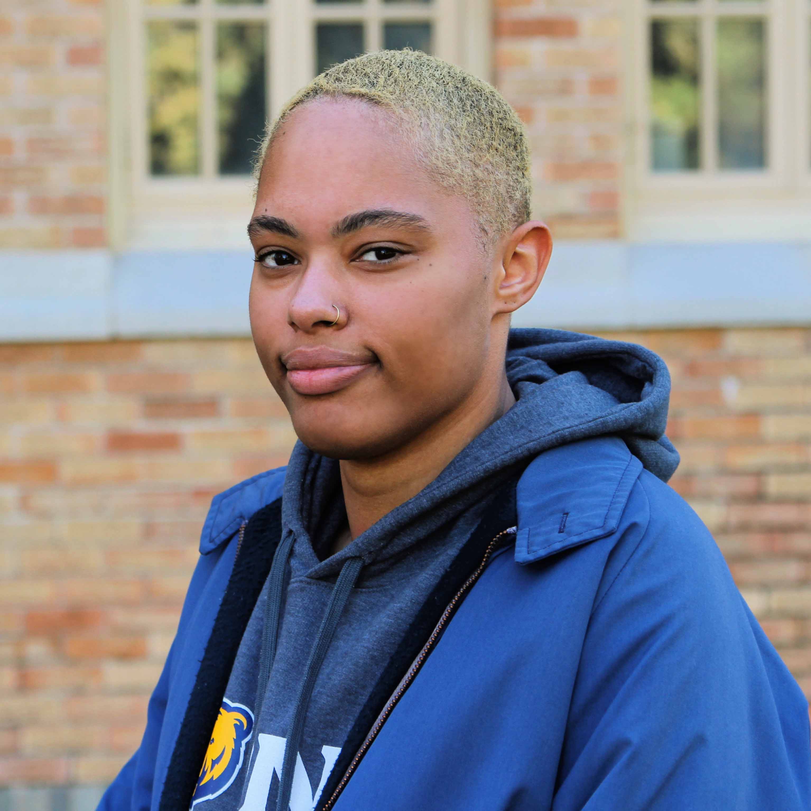A woman smiles while looking at the camera.