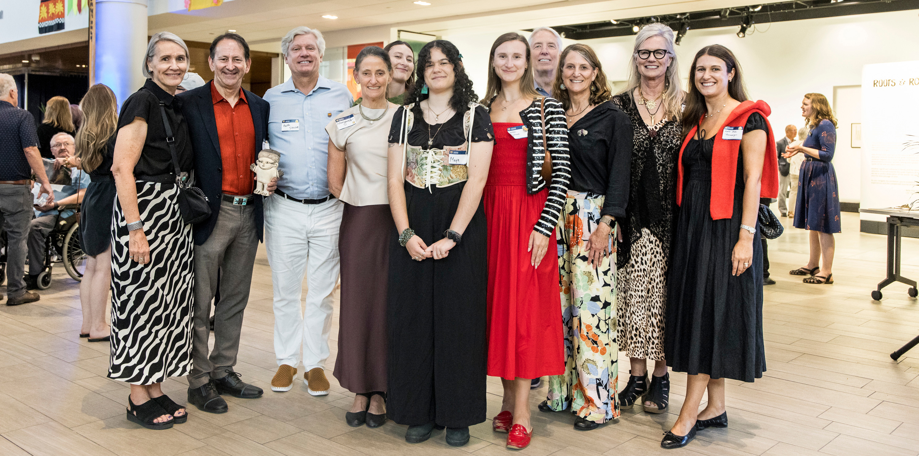 A group of people standing and standing next to each other posing for a picture