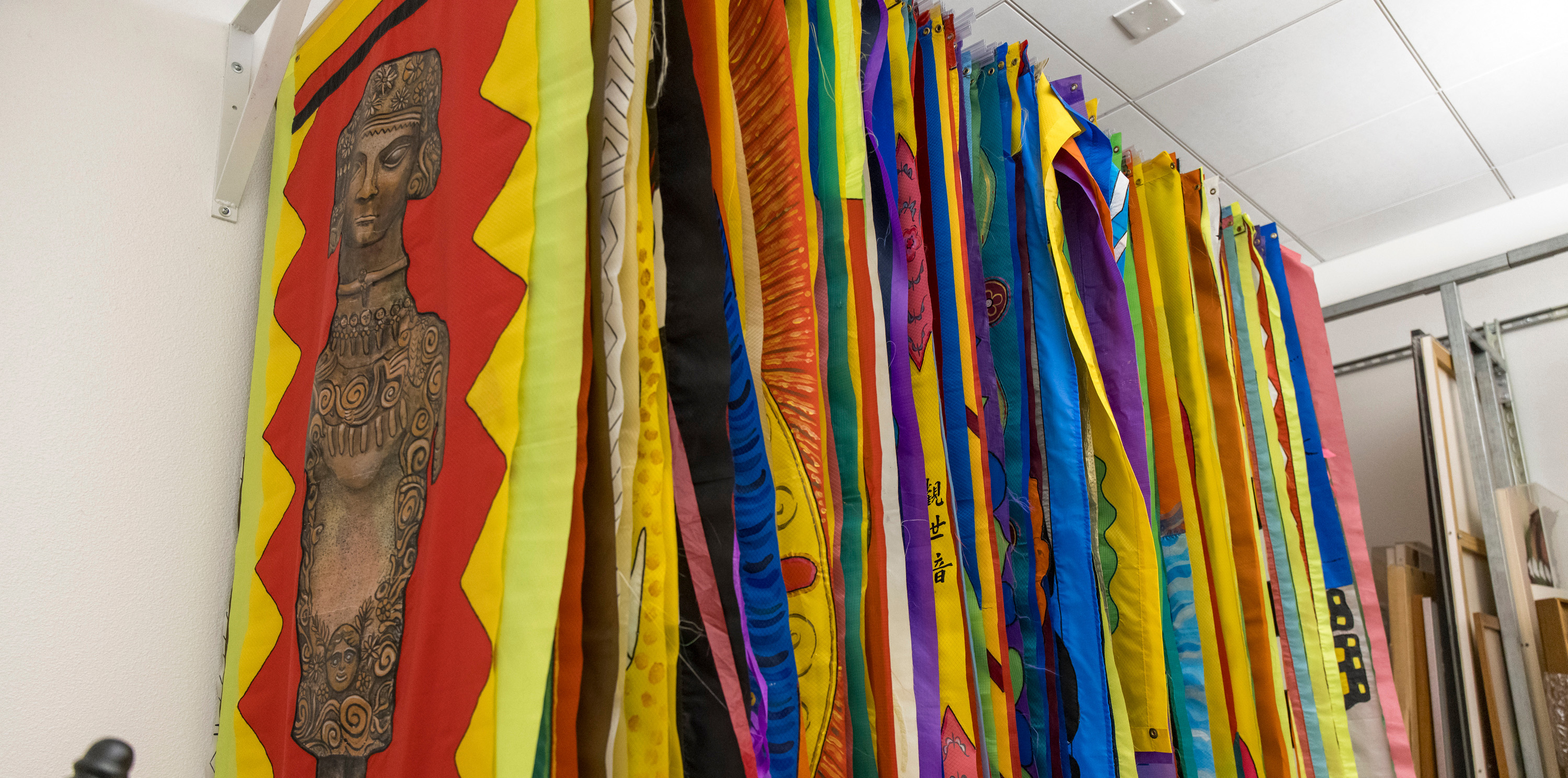 A group of Lydia Ruyle's vibrant flyers hanging up on a rod