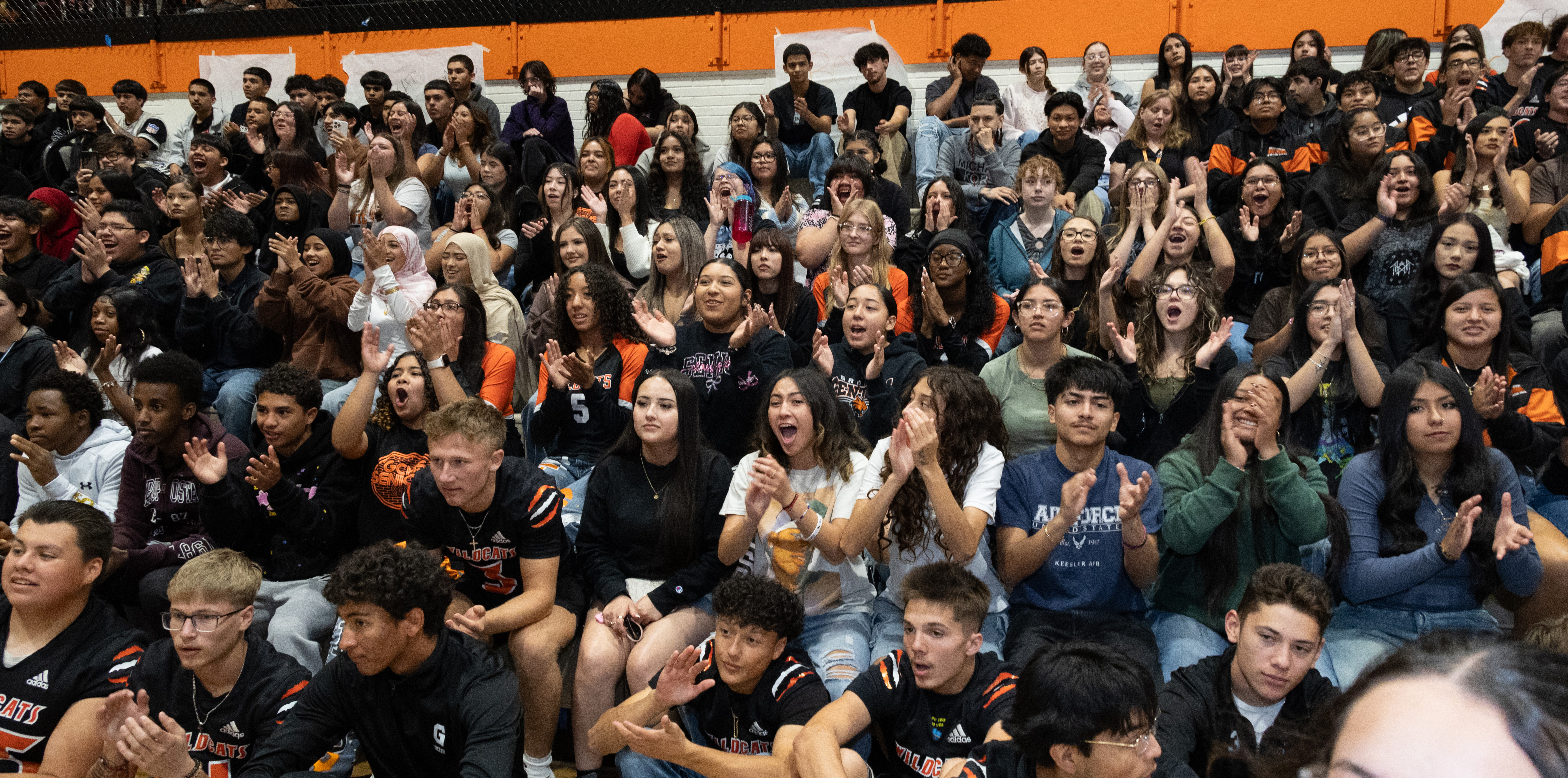 A large crowd of students cheering in the bleachers