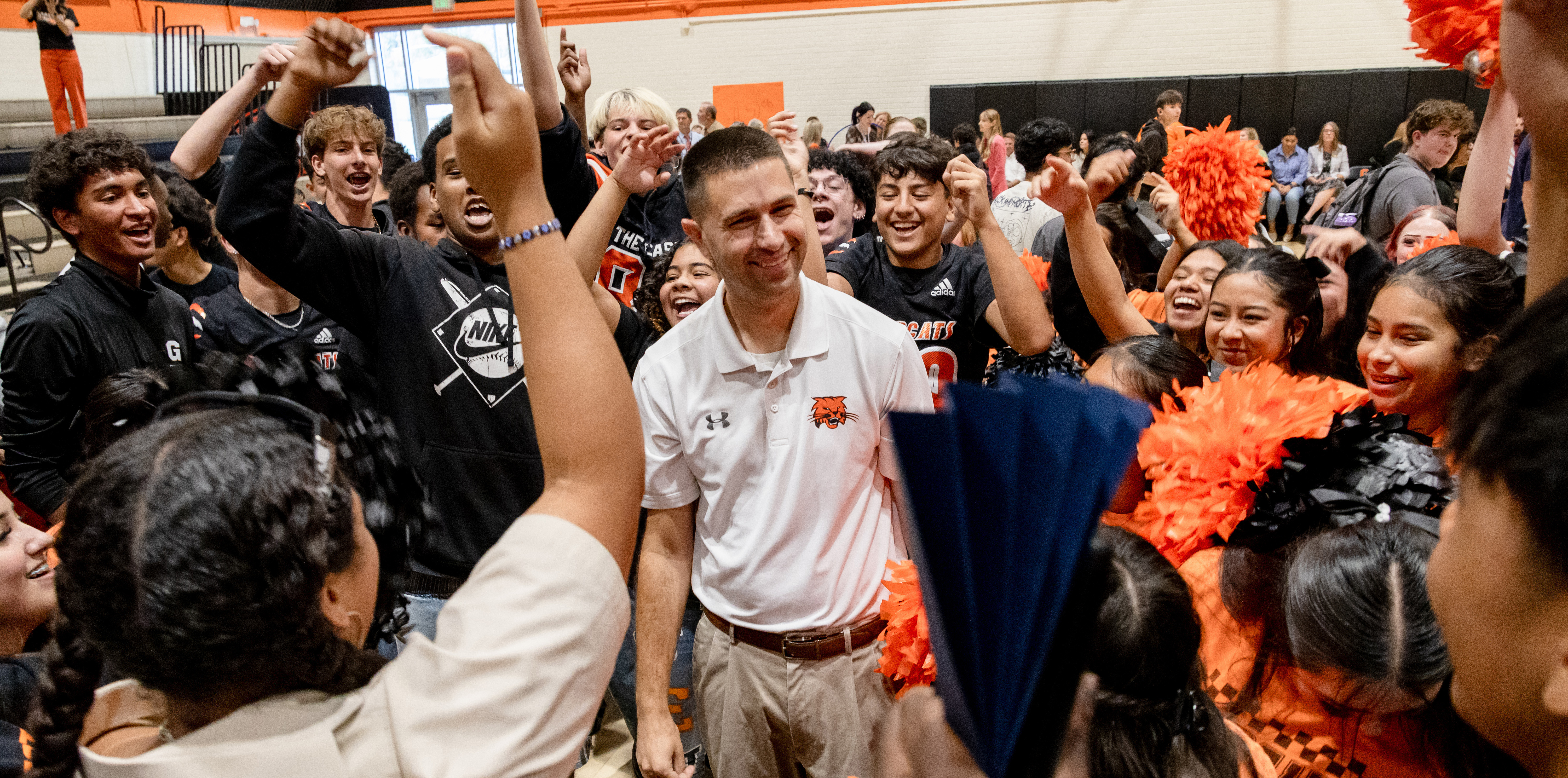A crowd cheering with Stephen Paulson standing in the middle and smiling