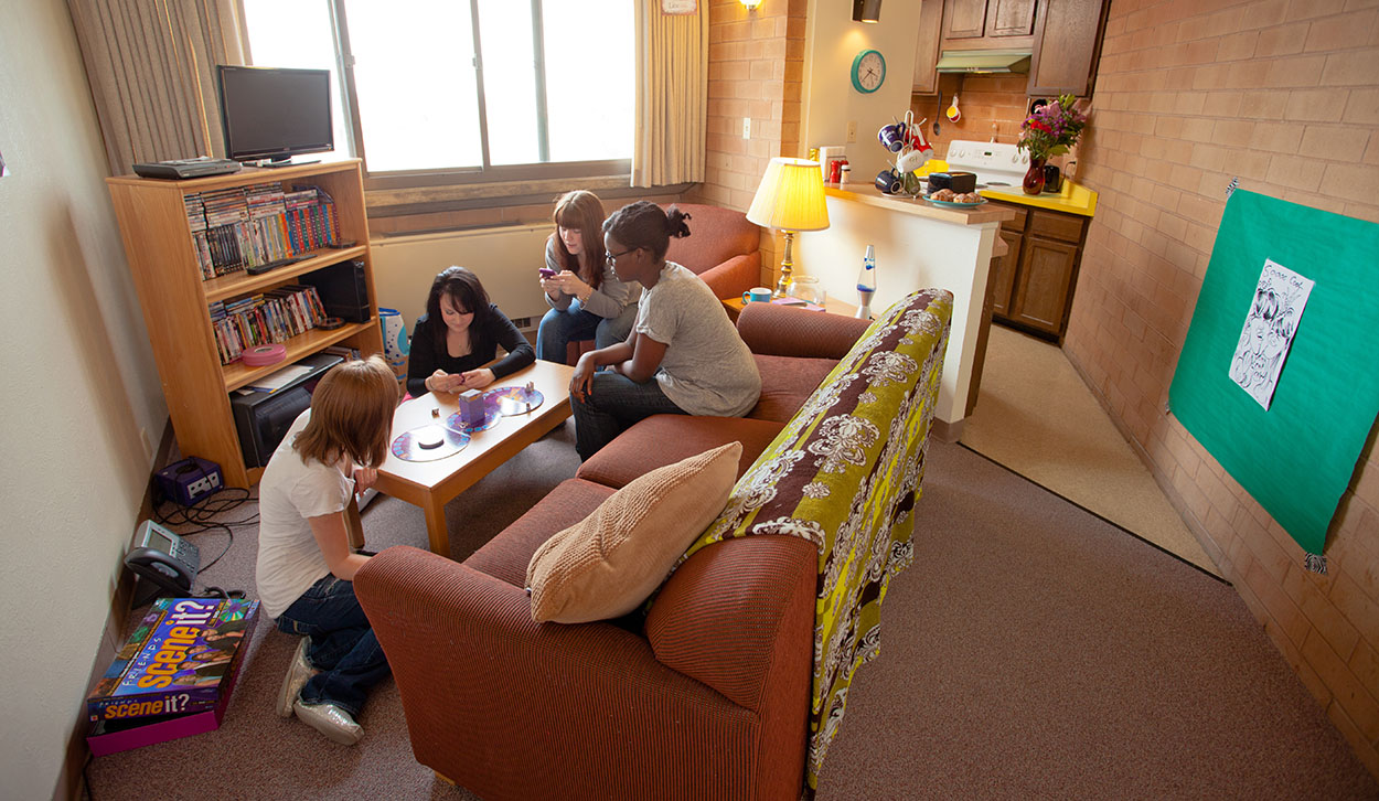 Students playing board games in the living room of an apartment.