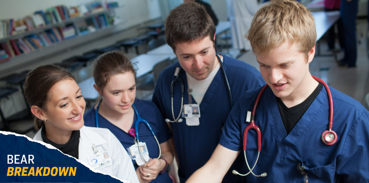Four UNC medical students in scrubs talking with each other