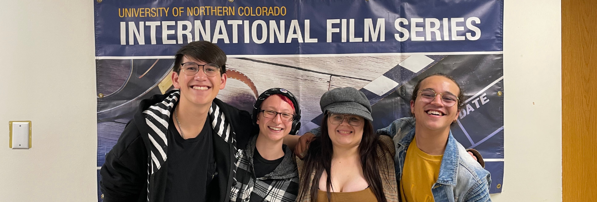 IFS student organizers pose in front of an IFS banner
